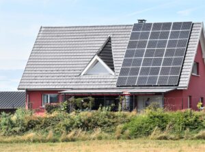 Einfamilienhaus mit Solarmodulen halbbelegt auf der rechten Seite des Daches