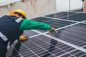Bauarbeiter verschraubt Solarmodul